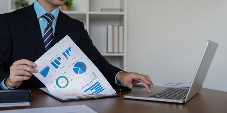 Professional Analyzing Financial Reports at Office Deskの写真素材