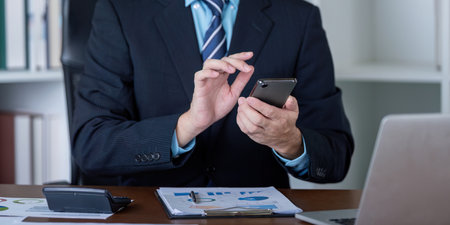 Business Professional Using Smartphone in Office Settingの写真素材