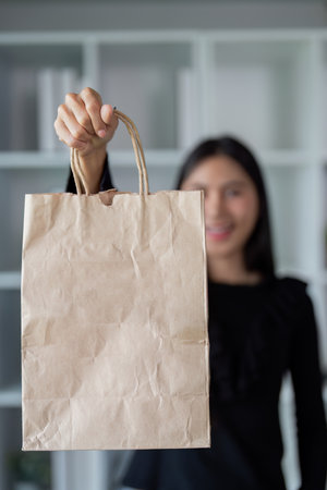 Asian woman showcasing an eco friendly shopping bagの写真素材