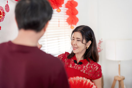 Elderly couple celebrating chinese new year at home embracing traditions in a joyful environmentの写真素材