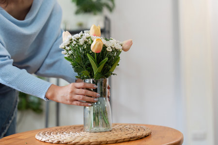 Arranging fresh tulips in a vase home interior floral decoration cozy environment close up view aesthetic appealの写真素材
