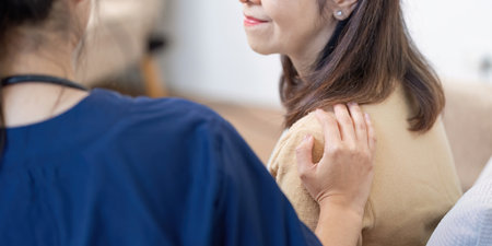 Caregiver checking symptoms of elderly patient with nurse and doctor in comfortable home environmentの写真素材
