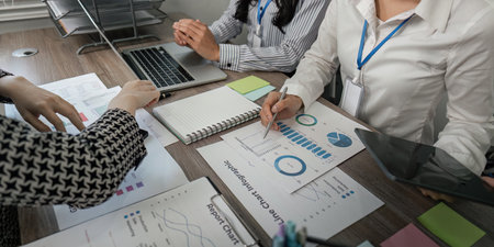 Business team analyzing charts and data reports in a collaborative workspace
