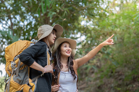LGBT couple exploring nature, pointing out sights during their hiking adventureの写真素材