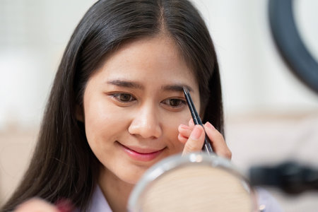 Beauty broker applying eyebrow makeup during a live broadcast tutorial