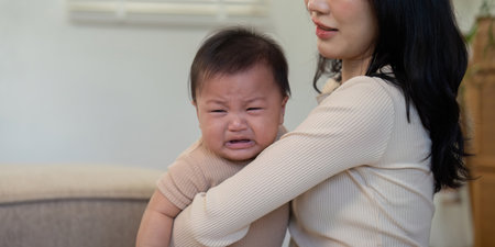 Mother soothing crying baby, experiencing emotions in a calm home setting