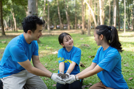 Family volunteers sharing smiles while planting a tree for environmental sustainability