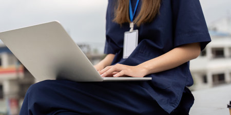 Nurse working on a laptop for patient documentation during a breakの写真素材
