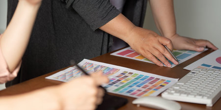 Diverse graphic design team analyzing color samples and prototypes at a table.