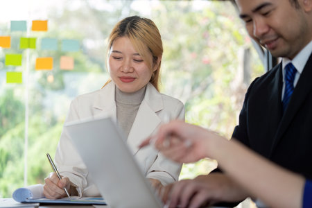 Diverse business team collaborating on analysis and discussion in a modern workspace.の写真素材