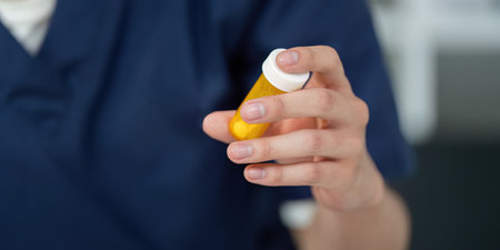 Medical student analyzing medication dosage with a prescription bottle, focusing on pharmaceutical education.の写真素材