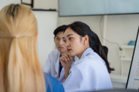 Healthcare professionals engaged in a focused discussion during a meeting.の写真素材