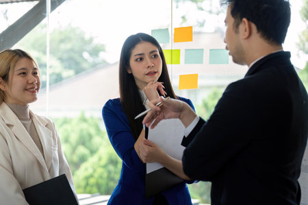 Diverse business professionals collaborating in a meeting, analyzing financial charts and strategies.の写真素材