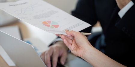 Team member presenting financial reports and graphs during a business meeting.