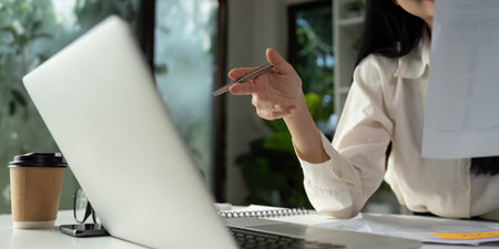 Accountant discussing financial strategies while holding a pen and reviewing documents.の写真素材