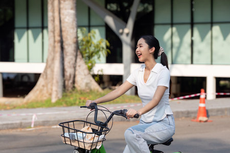 Smiling woman cycling with a joyful expression.の写真素材