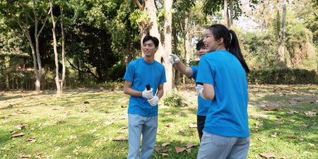 Sustainable volunteering. Volunteers celebrating teamwork during an eco project.の写真素材