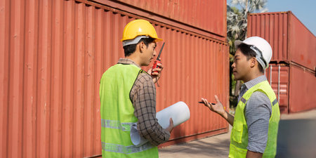 Logistics teamwork. Engineers discussing plans at a shipping container yard.