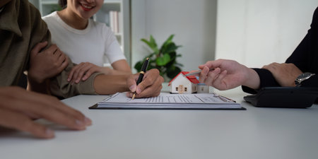 Real Estate and Partnership. A couple engaging with their real estate agent to finalize a home purchase.の写真素材