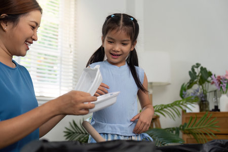 Sustainability Education and Family Values. A mother and daughter explore recyclable materials with a smile.の写真素材