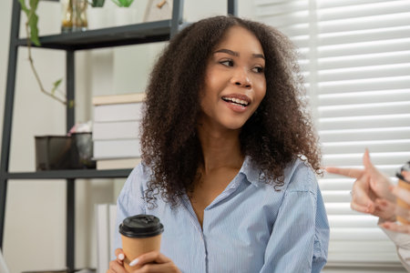 Engagement and Communication. A young professional listens attentively, engaged in conversation during a team meeting.の写真素材