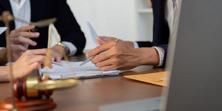 Legal Process and Documentation. Close-up of hands discussing legal paperwork.の写真素材