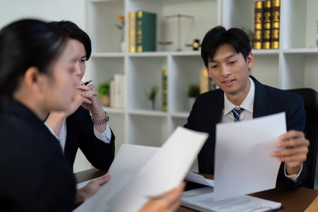 Documentation and Legal Insight. Lawyers reviewing important case files together.の写真素材
