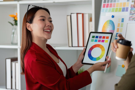 Creative Collaboration and Color Presentation. Team member showcases color options using digital tools to teammates.の写真素材