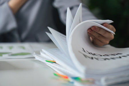Documentation and Reporting. A professional handling multiple financial reports.の写真素材