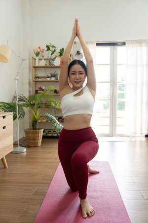 Yoga and Exercise. A woman reaching upward in a yoga pose, embracing balance and tranquility.の写真素材