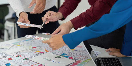 Collaboration and UX Design. Team members engaged in a collaborative UX design meeting, analyzing...