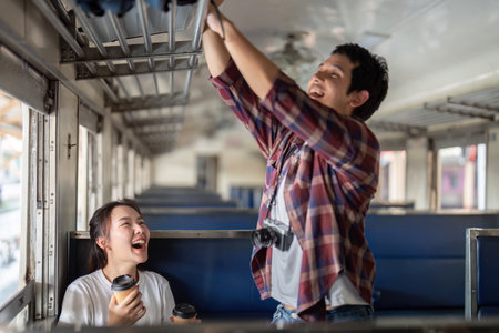 Laughter and Travel. A couple enjoying a fun moment together on a train journey.の写真素材