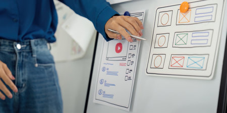 UX UI Planning and Review. A designer interacts with interface mockups in a structured design workshop.の写真素材