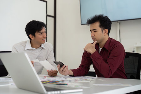 Two designers discuss a mobile interface while analyzing design elements.の写真素材
