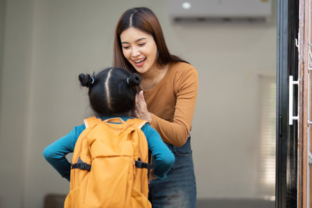Family Unity and Excitement for School. A mother welcomes her daughter with joy as she prepares for school.の写真素材
