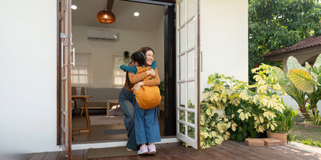 Back to School and Mother-Daughter Bonding. A joyful reunion as a mother hugs her daughter after coming home from school.の写真素材