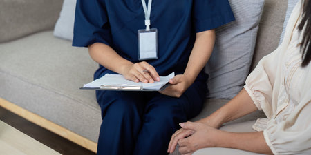 Home Healthcare and Patient Engagement. A caregiver in smart attire discusses health plans with a patient.の写真素材