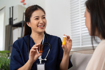 Caregiver and Patient Interaction. A caregiver discusses medications with an elderly patient, enhancing understanding and health management.の写真素材