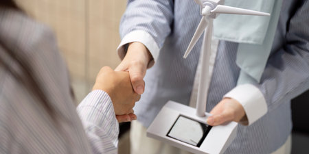Agreement and Momentum in Sustainable Innovation. Handshake between colleagues symbolizes a commitment to renewable energy projects.の写真素材