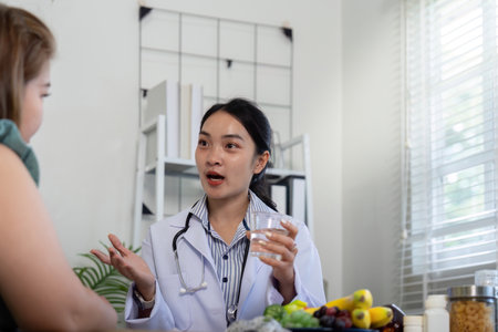 Nutrition and Patient Engagement. A healthcare professional discussing hydration and nutrition with a patient, highlighting health choices.の写真素材