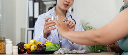 Nutrition and Wellness. A nutritionist discussing healthy fruit options with a patient.の写真素材