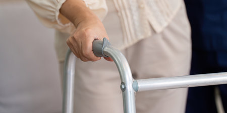 Caregiver and Elderly Support. A close-up of a hand gripping a walker, symbolizing stability and independence for seniors.の写真素材