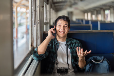 Travel and Connectivity. A young man happily chatting on the phone while embarking on a journey.