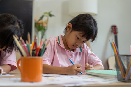 Focus and Learning. A girl deeply concentrated on her drawing at school.の写真素材