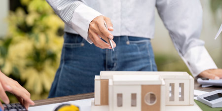 Sustainability and Eco-Design. Professionals analyzing a model of an eco-friendly building.の写真素材