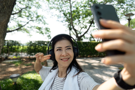 Wellness through self-care: Elderly woman taking selfie outdoors