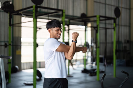 Wellness and Flexibility. Young man stretching at gym.