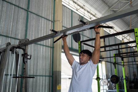 Wellness and Strength. Man performing pull-ups for fitness and muscle building.