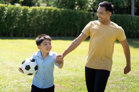 Activity: Father and Son Playing Soccer Together with Joyの写真素材