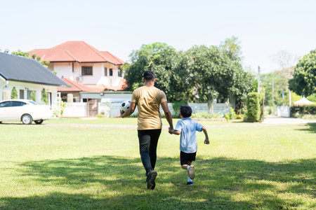 Activity: Father and Son Running Together in the Gardenの写真素材